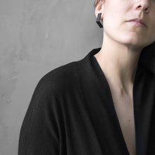 Load image into Gallery viewer, A woman wearing the Black Square Earrings with a black bluse on a grey background