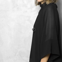 Load image into Gallery viewer, A woman with a blond hair wearing the Black Zero Necklace in the snake option with a black bluse on a grey background
