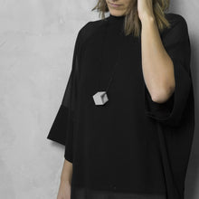 Load image into Gallery viewer, A woman with a blond hair wearing the Grey Zero Necklace snake option with a black bluse on a grey background