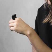 Load image into Gallery viewer, A woman wearing the Megalith Ring on their finger on a concrete grey background