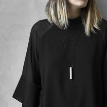 Load image into Gallery viewer, A woman with a blond hair wearing the White MODULOQUATTRO Necklace with a black bluse on a grey background