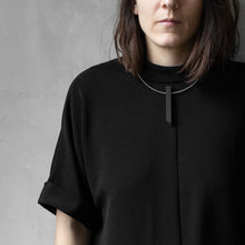 Load image into Gallery viewer, A woman with a blond hair wearing the Black Column Necklace with a black bluse on a grey background