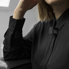 Load image into Gallery viewer, A woman with a blond hair wearing the Black Zero Necklace with a black bluse on a grey background