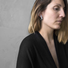 Load image into Gallery viewer, A woman with a blond hair wearing the Grey Square Earrings with a black bluse on a grey background
