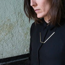 Laden Sie das Bild in den Galerie-Viewer, Architectural necklace worn in an urban setting with natural light emphasizing its geometric silhouette.