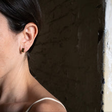 Laden Sie das Bild in den Galerie-Viewer, Minimalist gold square earrings styled against contemporary architecture and contrasting light.