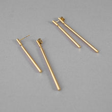 Laden Sie das Bild in den Galerie-Viewer, Contemporary gold-plated statement earrings inspired by architectural lines and balance.