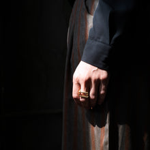 Laden Sie das Bild in den Galerie-Viewer, QUADRA architectural ring worn on hand in an urban setting, highlighted by dramatic sunlight and geometric shadows.