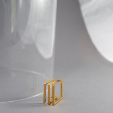 Laden Sie das Bild in den Galerie-Viewer, Gold-plated stainless steel statement ring with transformable square structure, handcrafted in Berlin.