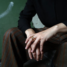 Laden Sie das Bild in den Galerie-Viewer, Minimalist geometric gold ring worn outdoors in the city, reflecting natural light and architectural surroundings.