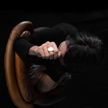 Load image into Gallery viewer, a woman wearing the rhodium square ring while she are sitting on a brown armchair