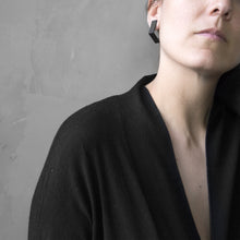 Load image into Gallery viewer, A woman wearing the Black Square Earrings with a black bluse on a grey background 