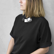 Load image into Gallery viewer, A woman with a blond hair wearing the Zero Elements Necklace with a black bluse on a grey background 
