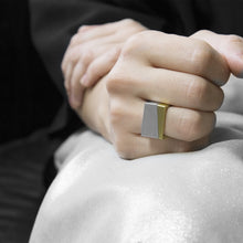Load image into Gallery viewer, close-up of hand are wearing the Assembled ring, a combination of Aluminium square ring and brass square ring